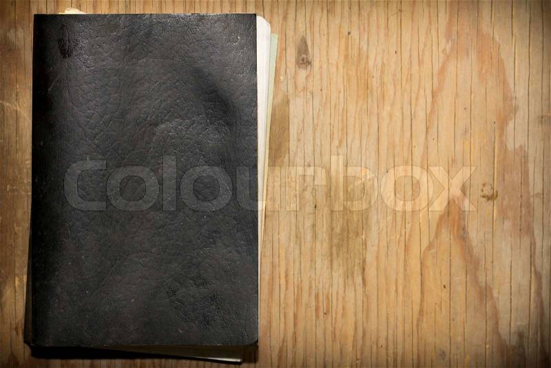 The old, wise book lies on a wooden background, stock photo