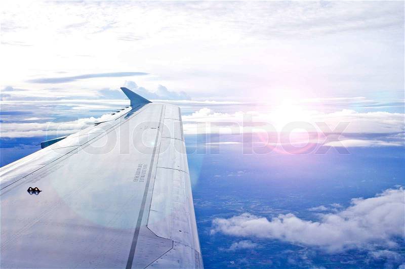 View of jet plane wing with cloud patterns, stock photo