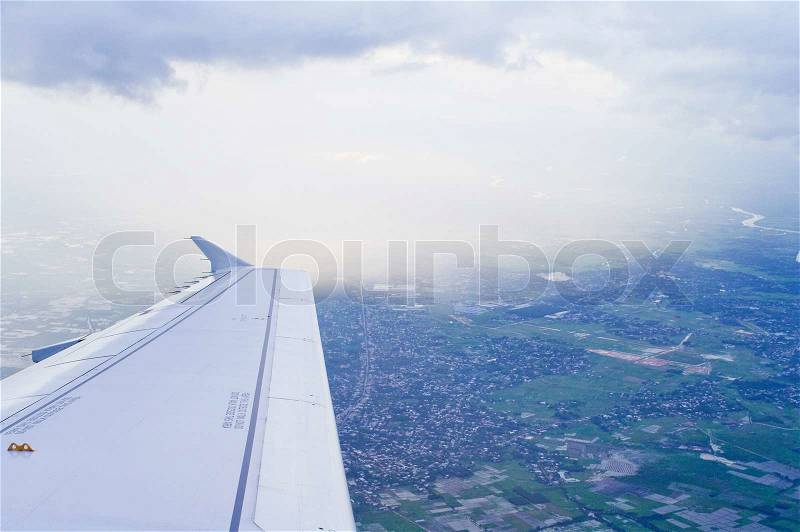 View of jet plane wing with cloud patterns, stock photo