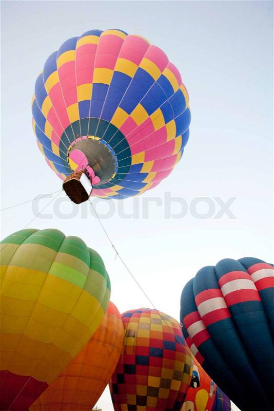 Silhouette hot air balloon landing with many people, stock photo