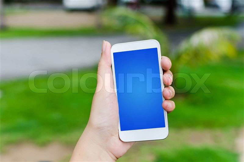Hand Holding Mobile Phone in the nature, stock photo