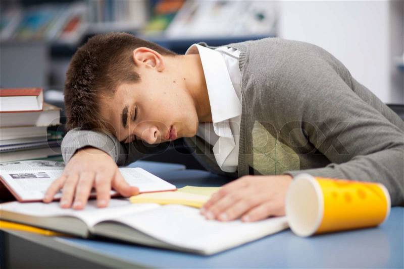 Tired student sleeping at the desk, stock photo