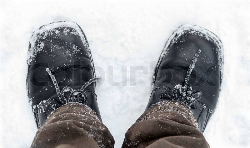 Black leather men\'s shoes on the feet with snow, stock photo