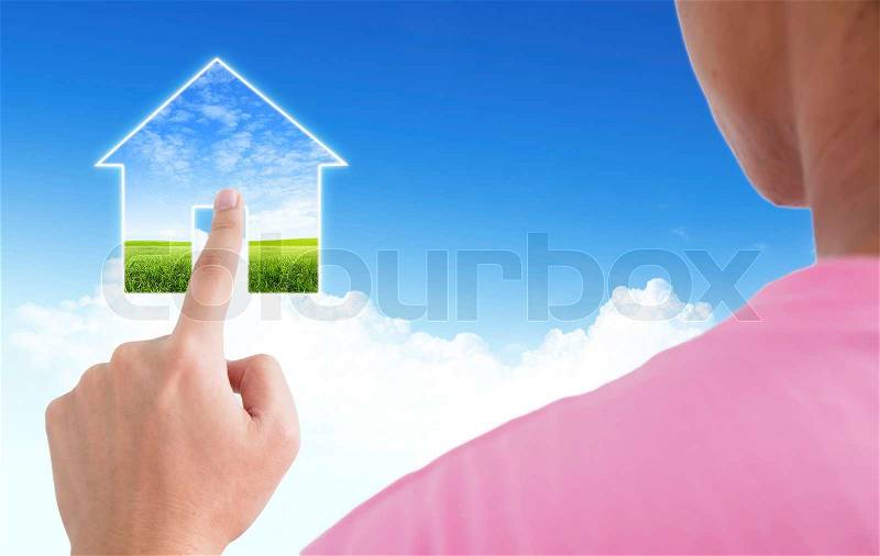 Man point finger on the screen with blue sky as a symbol of the real estate business, stock photo