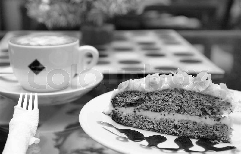 Cappuccino and poppy seed cake on cafe table outdoors Cappuccino and poppy seed cake focus on the cake, stock photo