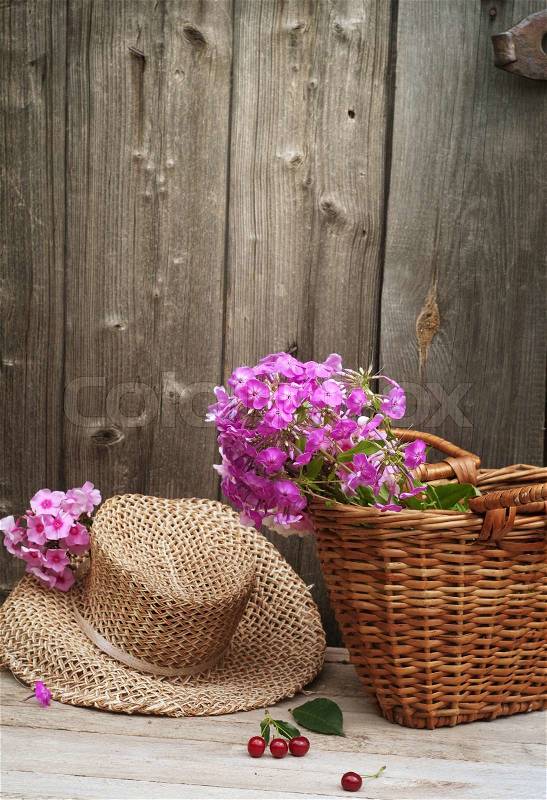 Basket of flowers and a straw hat, stock photo