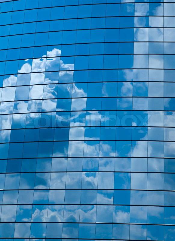Clouds reflected in windows of modern office building, stock photo