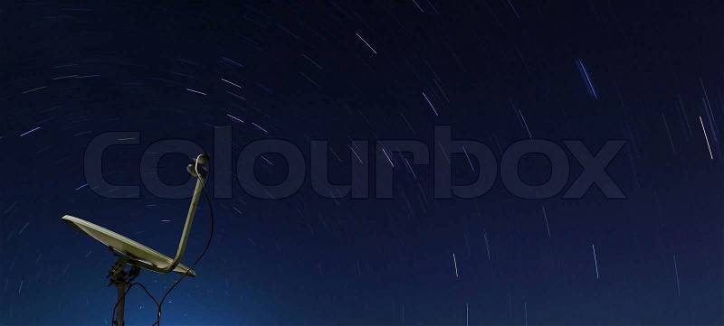 Conceptual of yellow satellite over spiral star at night, stock photo