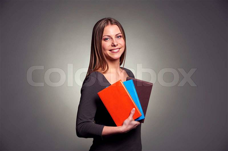 Pretty young woman holding the books, stock photo