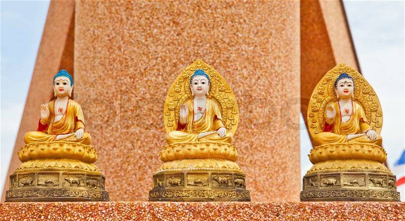 Three Buddha statue sitting on a wall, stock photo