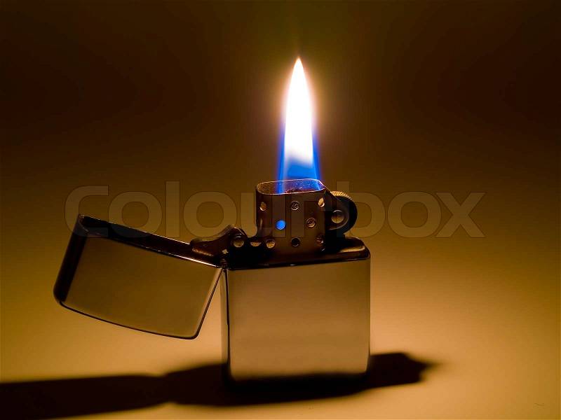 A cigarette lighter with a yellow and blue flame, stock photo