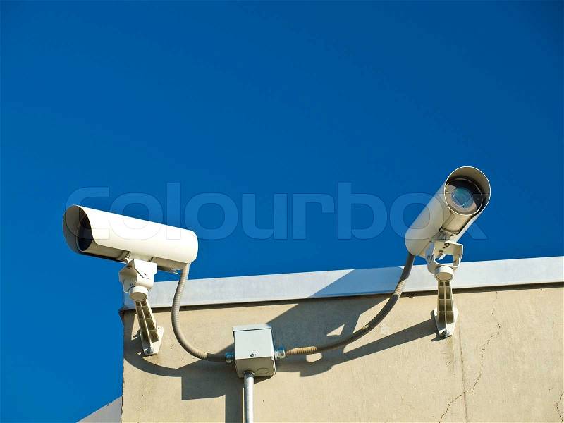 Security Cameras Performing Surveillance on the Side of a Building, stock photo