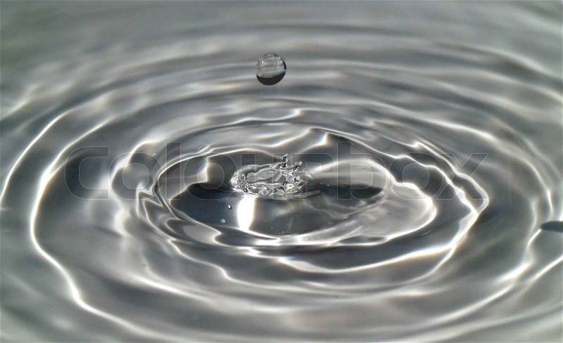 Macro of a water droplet and ripples, stock photo