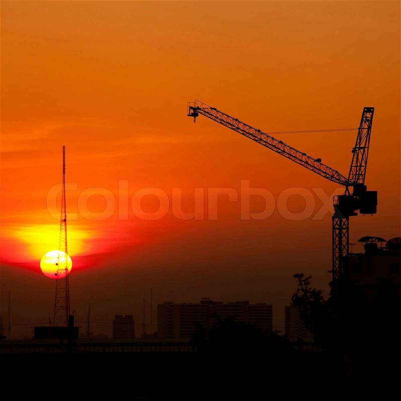 Crane in construction site at sunset, stock photo