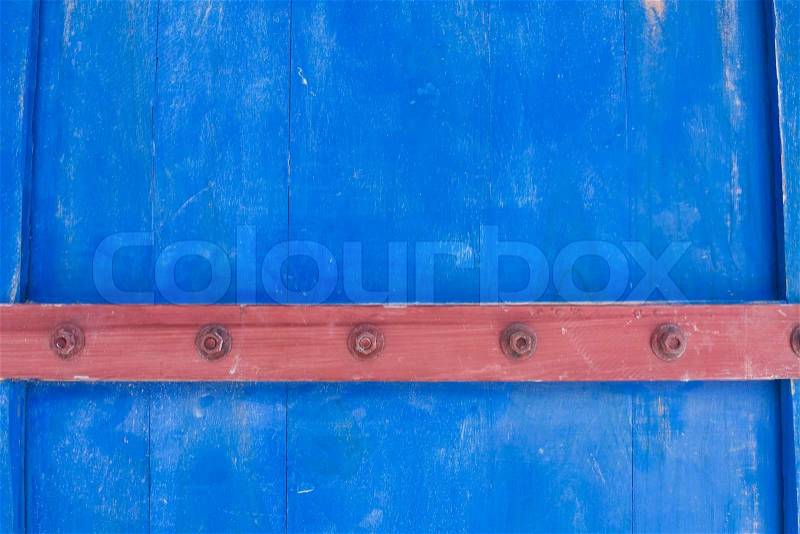 Weathered blue wooden door texture with rusty forged nail heads, stock photo