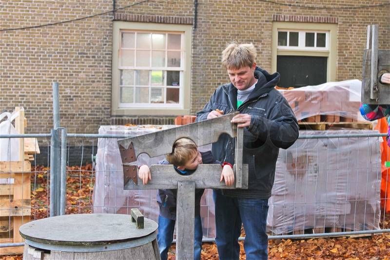 Father shows his son device pillory in the Dutch suburb Netherlands, stock photo