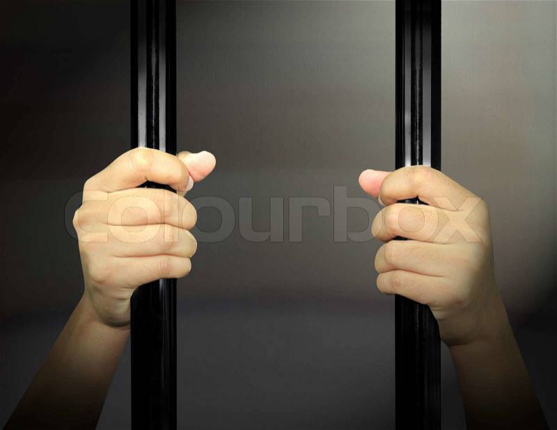 Hands of the prisoner on a steel lattice, stock photo