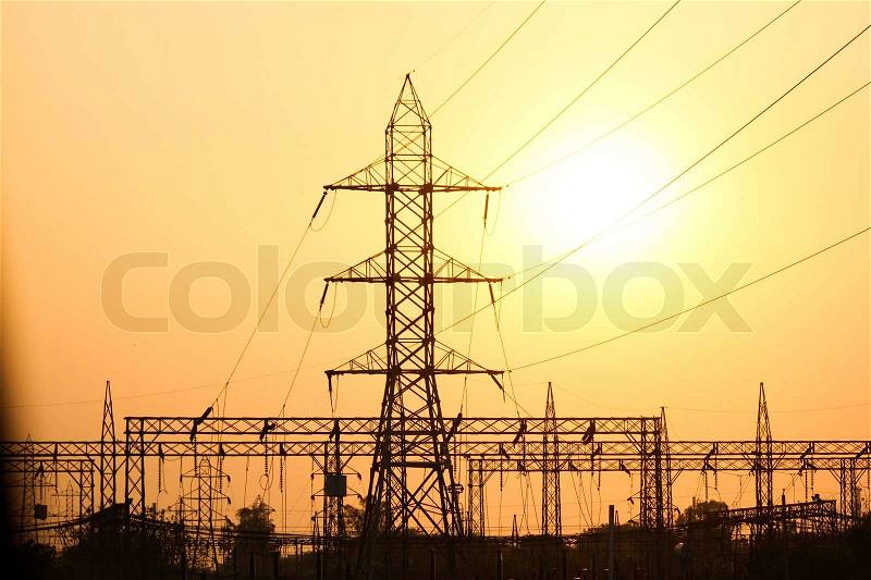 Electricity pylons and lines at sunset in India, stock photo