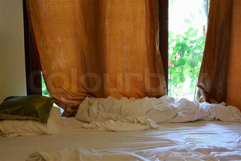 Interior shot of motel room with unmade bed, stock photo