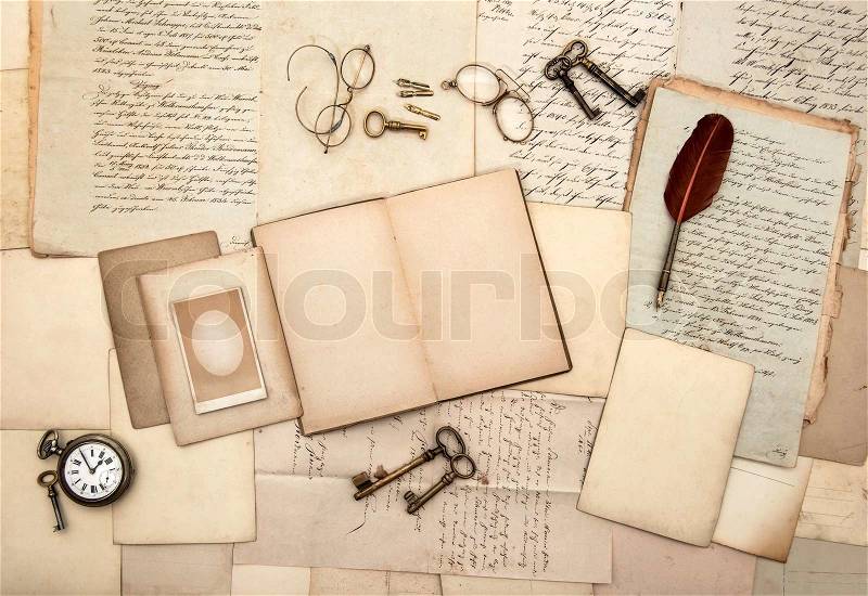 Open book, old letters, post cards, glasses, keys, clock, stock photo