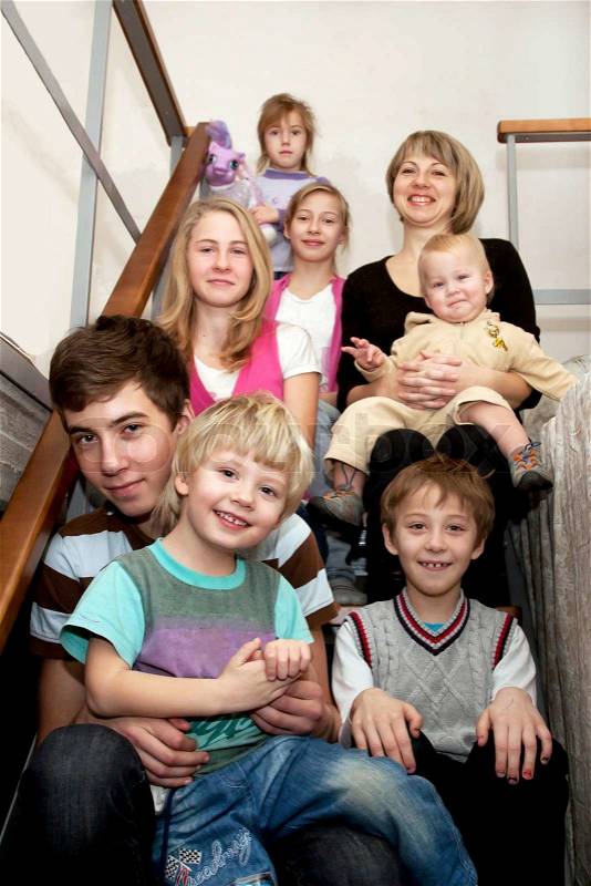 Big happy family sitting on the stairs at home, stock photo
