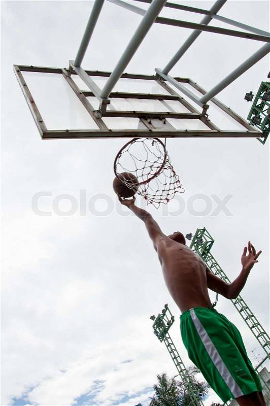 Silhouette of boy dunk basketball, stock photo