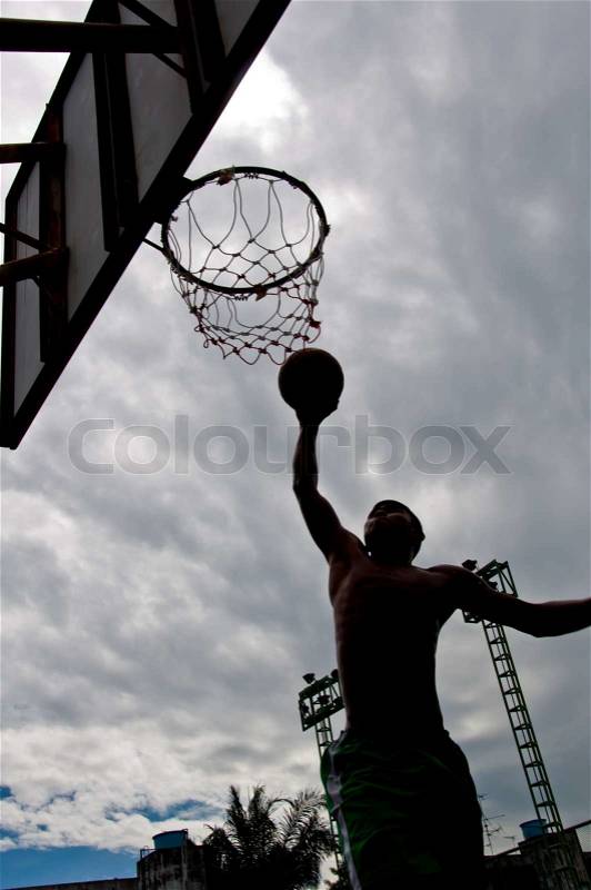Silhouette of boy dunk basketball, stock photo