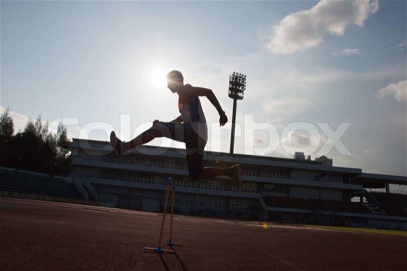 Silhouette of man hurdle jump, stock photo