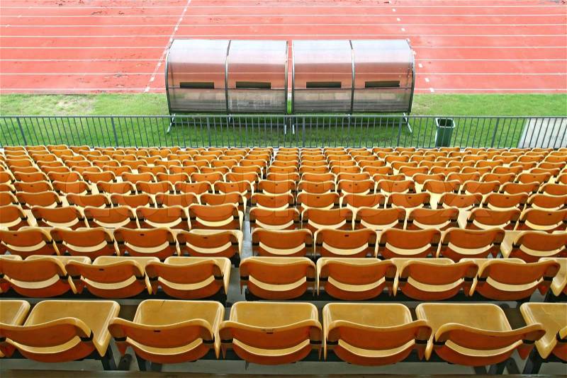 Coach and reserve benches with yellow seats in football stadium Back Perspective, stock photo