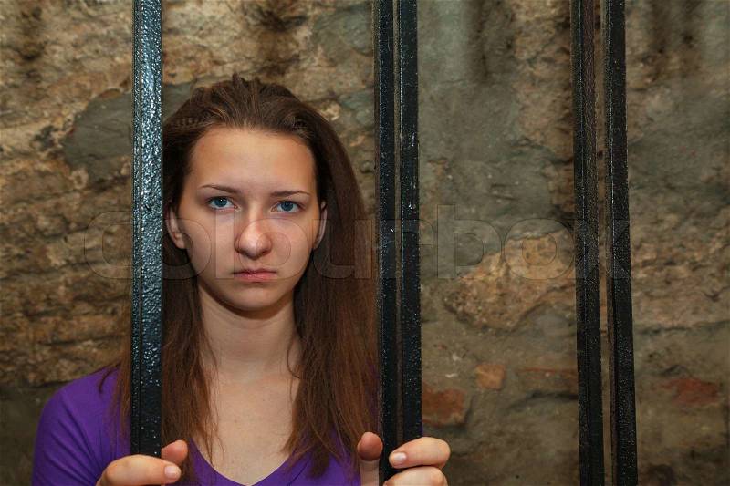 Young woman behind the bars, stock photo