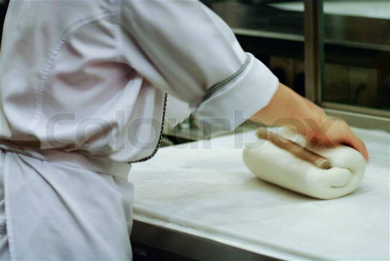 Baker making bread , woman hands , kneading a dough , cooking coat, stock photo