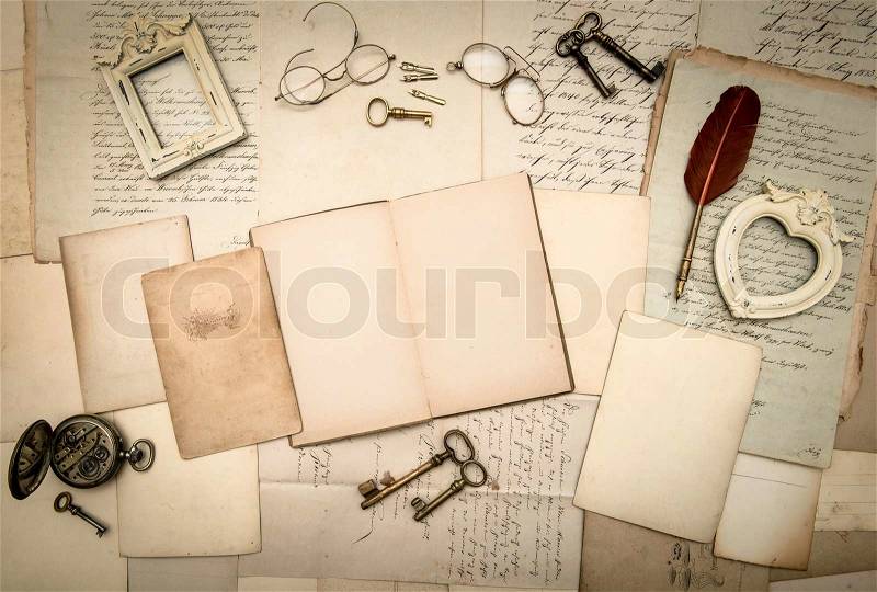 Open book, vintage accessories, old letters, pages, photo frames, glasses, keys, clock. nostalgic background, stock photo