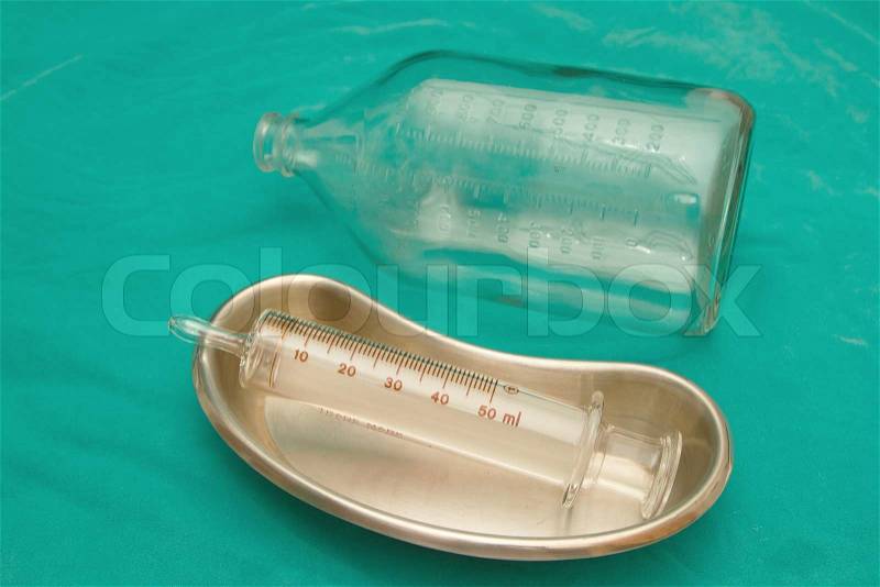 Glass syringe in sterile basin and glass bottle for tube feeding diet, stock photo