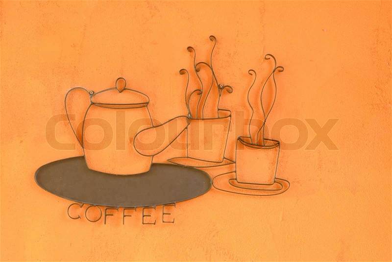 Curved steel Kettle and coffee cup on wall, stock photo
