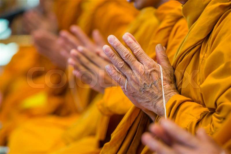 Buddhist monks chanting focus on one hand, stock photo