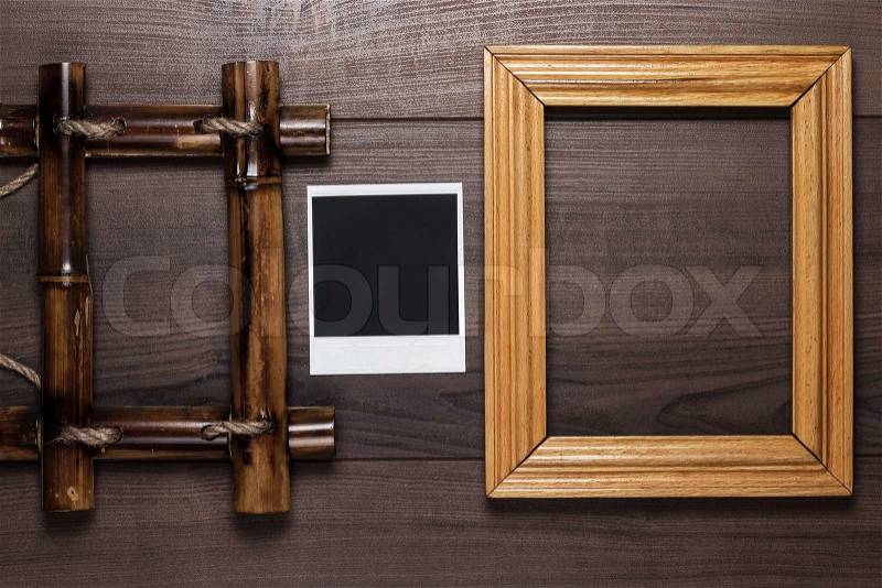 Empty frames and old photo on the wooden table background, stock photo