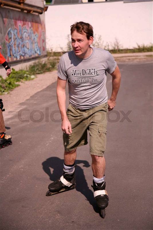 Grown up man on roller skaters, stock photo