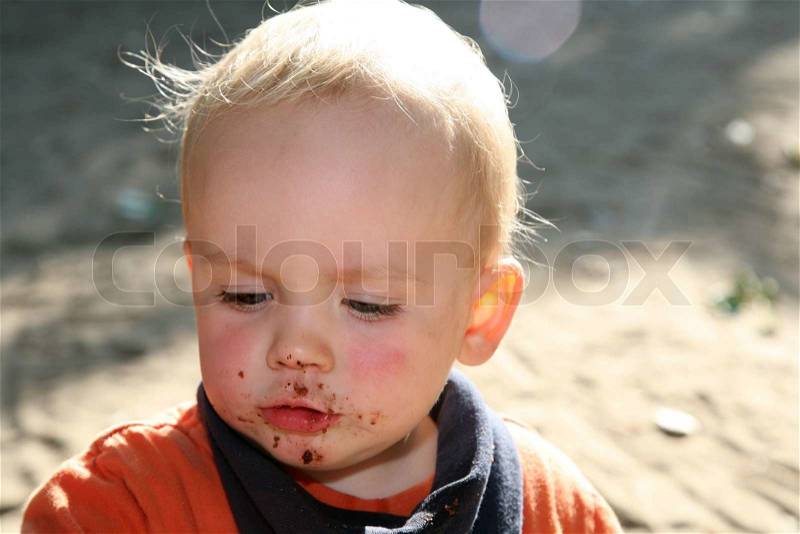 Close-up on cute blond baby with dirty mouth, stock photo