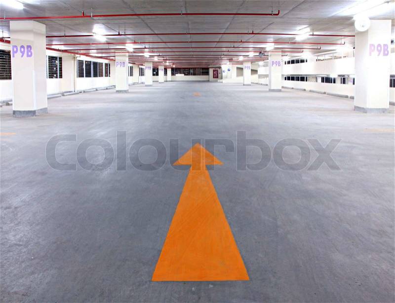 Empty parking garage with yellow arrow, stock photo