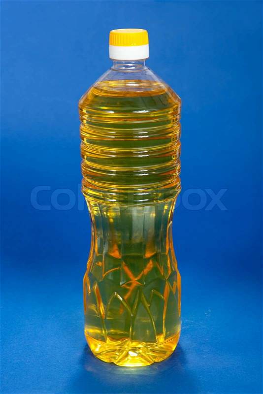 Cooking oil bottle on blue background, stock photo