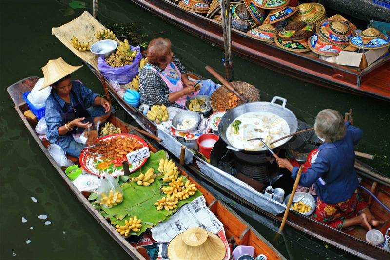 RATCHABURI, THAILAND - JULY 5: Local people sell food items at Damnoen Saduak floating market on July 5, 2009 in Ratchaburi, Thailand. Damnoen Saduak is a very popular tourist attraction, stock photo