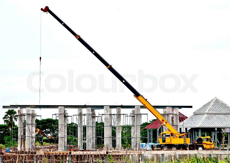 The yellow automobile crane lifted equipment for under construction, stock photo