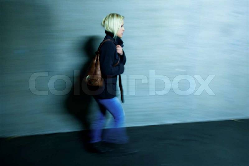 A young woman in an underpass for pedestrians fear of harassment and crime, stock photo