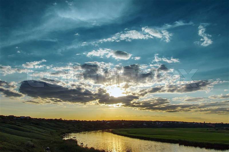 Cloudy sunset over river, stock photo