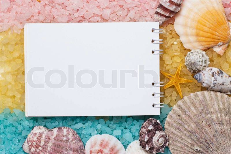 Blue yellow pink bath salt and blank notepad background, stock photo