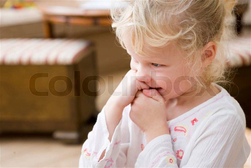 A cute girl biting her nails, stock photo