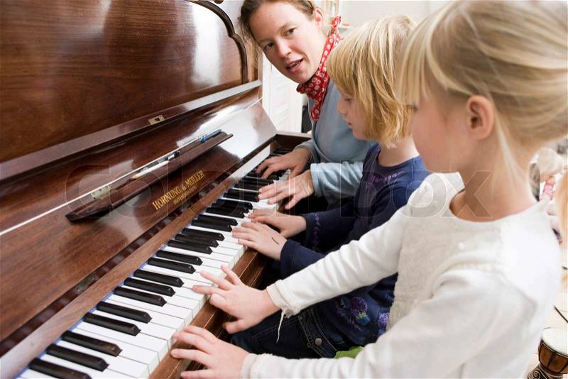 A young girl learning to play the piano, stock photo