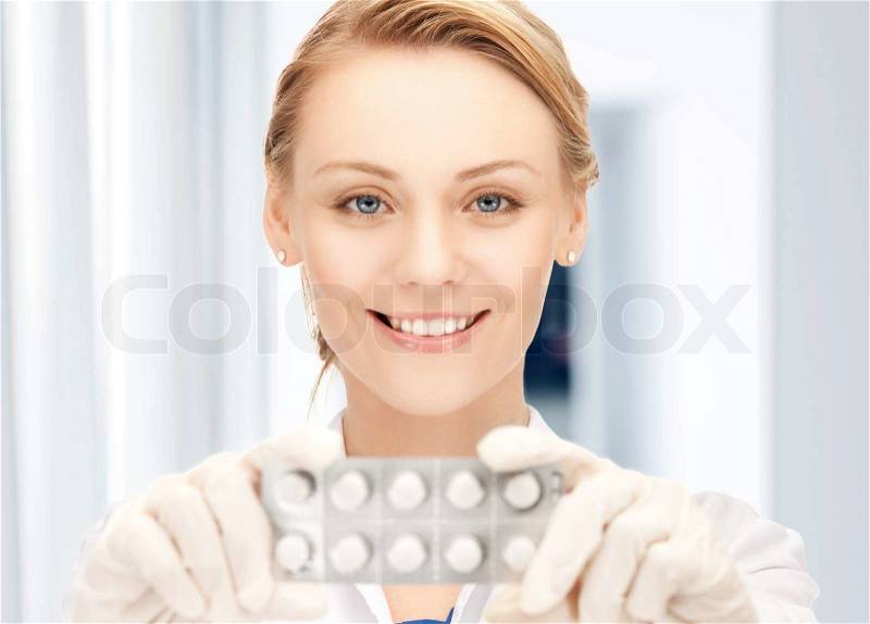Picture of attractive female doctor with pills, stock photo