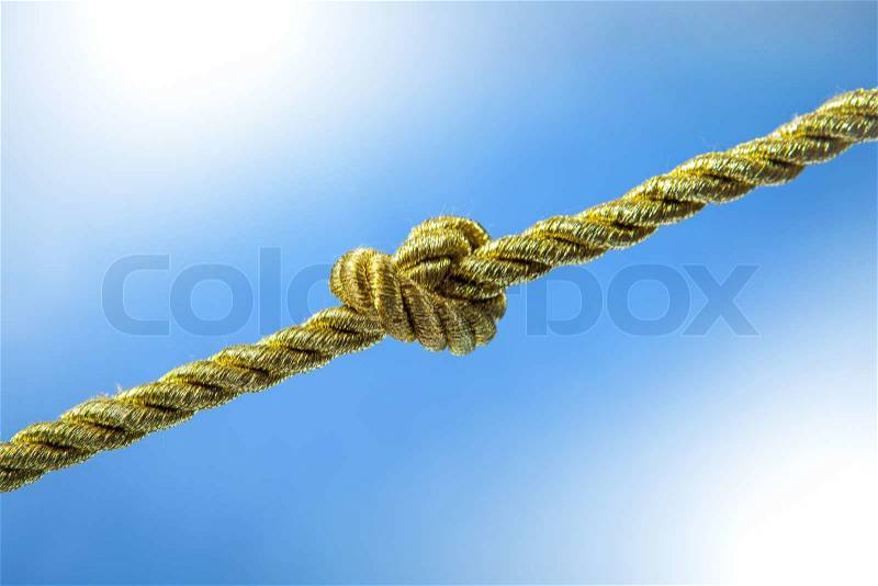Gold rope knot on a blue background, stock photo