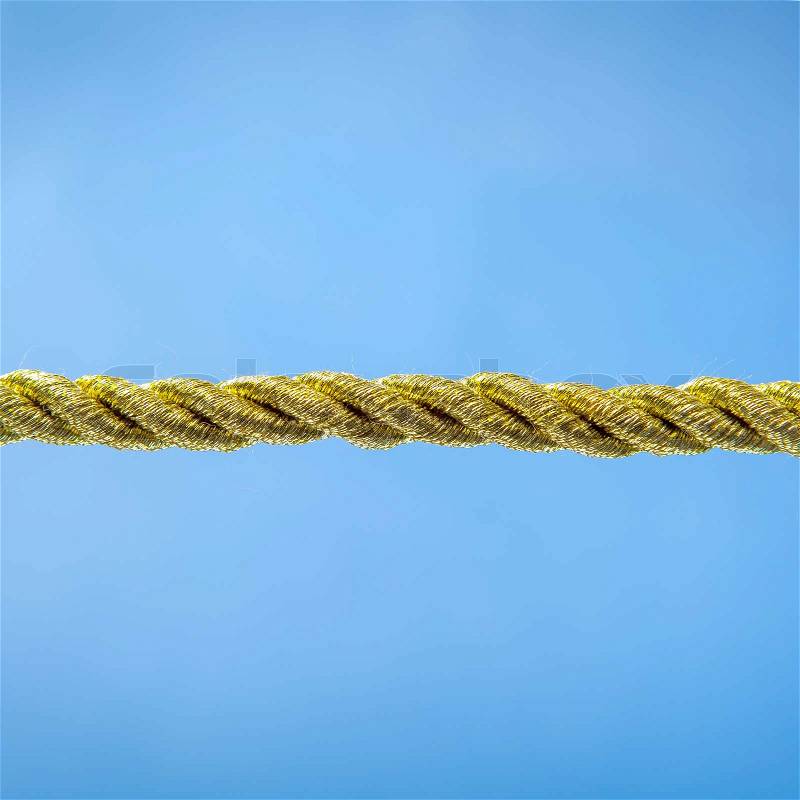 Gold rope on a blue background, stock photo